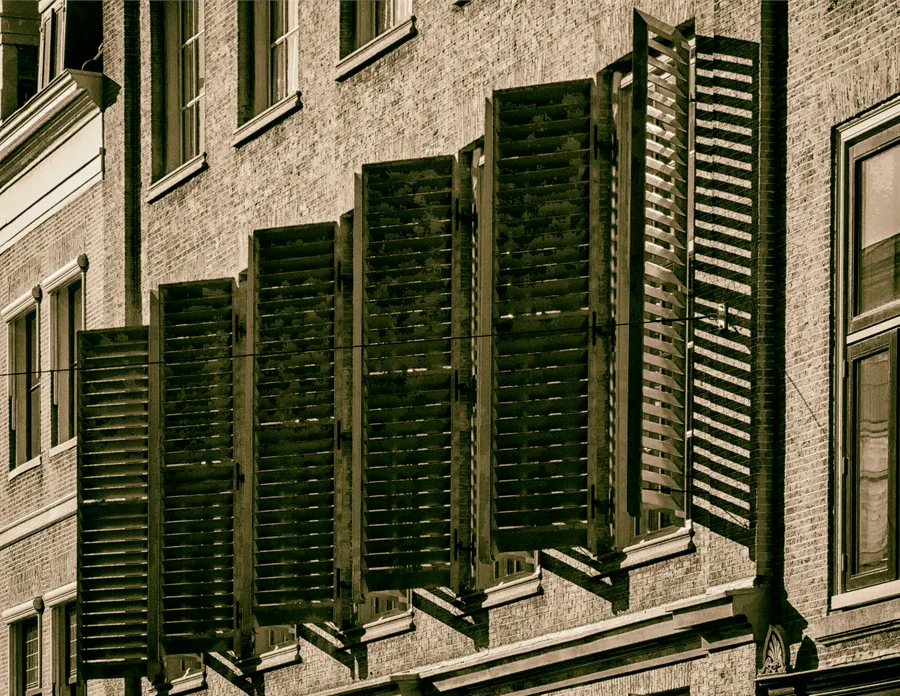 Offene Holzfensterläden an einem Backsteinbau