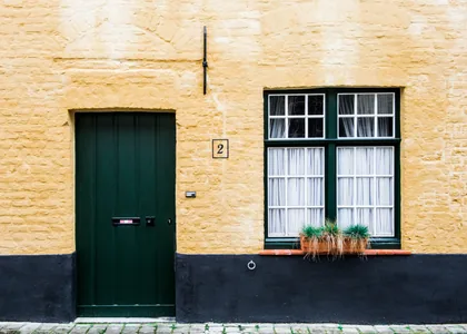 Green Door and Window in a Yellow Wall
