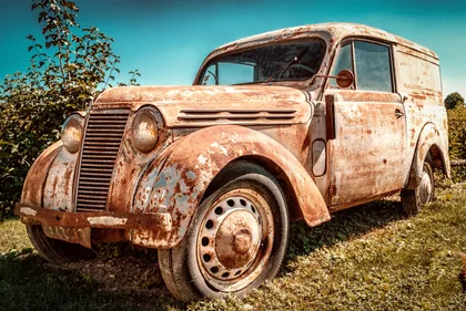 Una camioneta oxidada entre la hierba alta