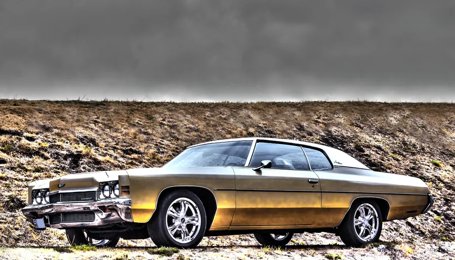 A Gold Chevrolet Against a Grassy Bank