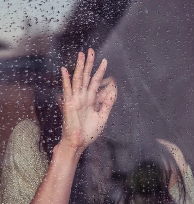 A Hand on a Rain-Streaked Window
