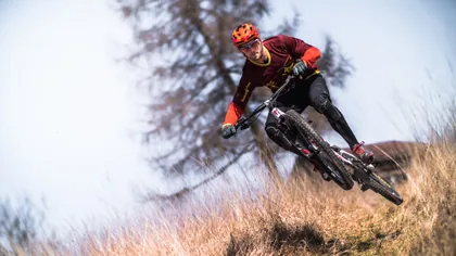 A Mountain Biker Cornering on a Hillside