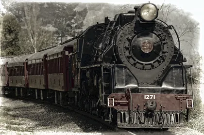 Una locomotora de vapor con vagones granate