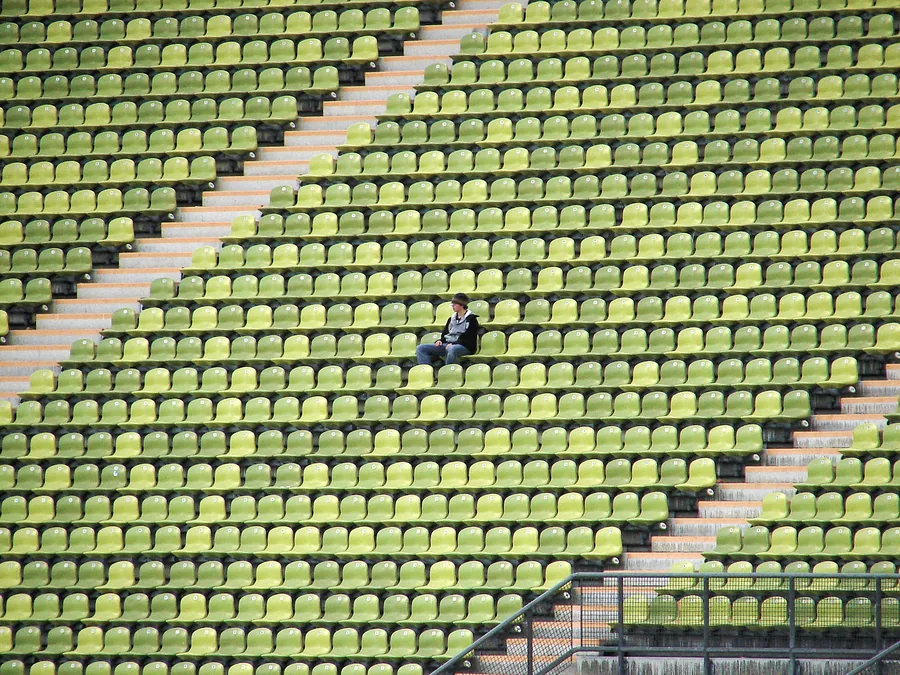 Ein einzelner Zuschauer in leeren Stadionreihen