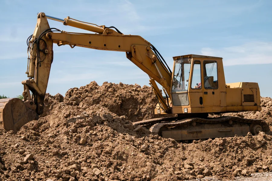A Yellow Excavator on a Mound of Earth