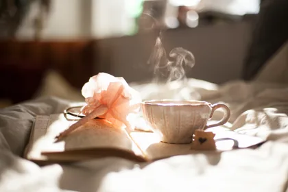 Taza de té y cuaderno a la luz de la mañana